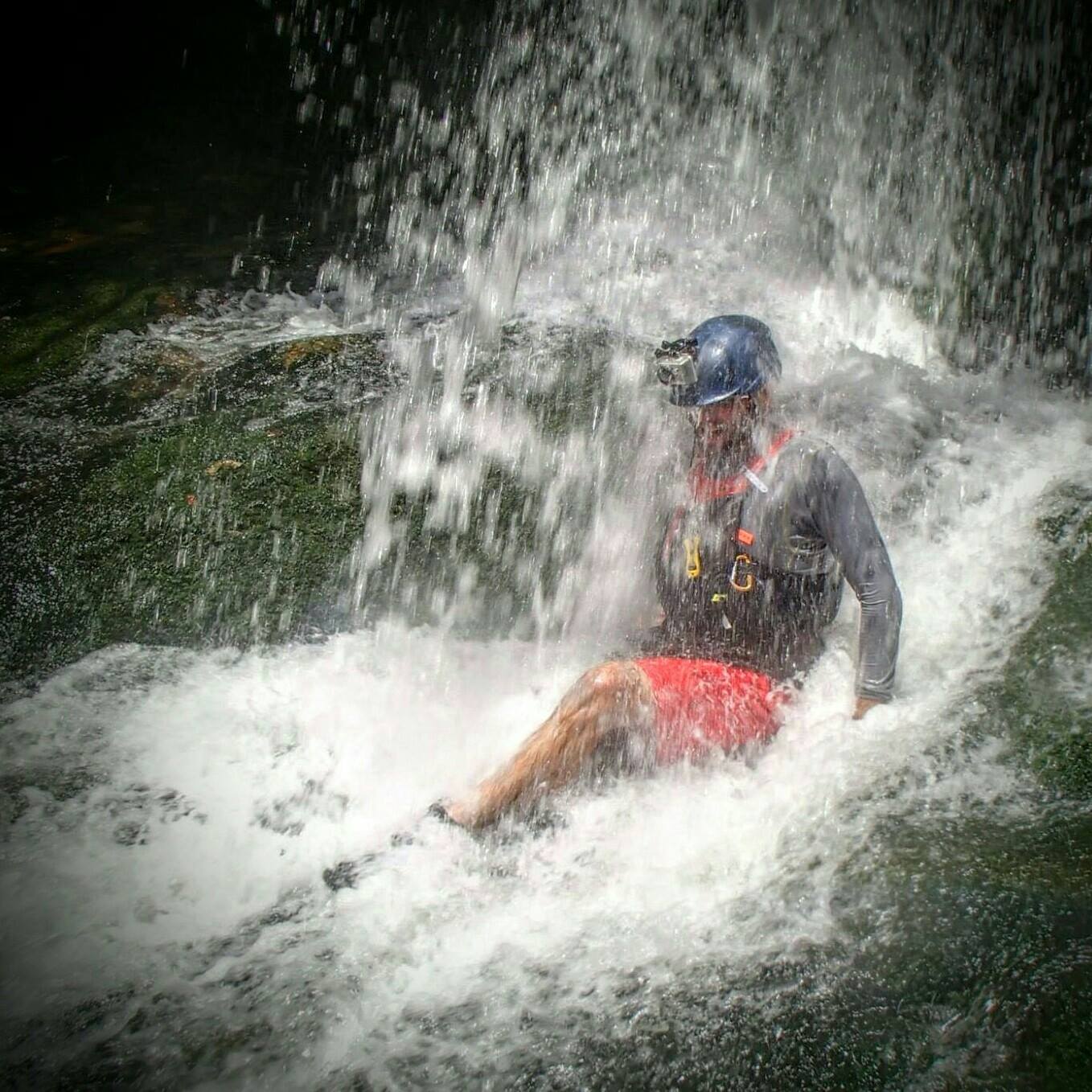 Ian sitting under a waterfall